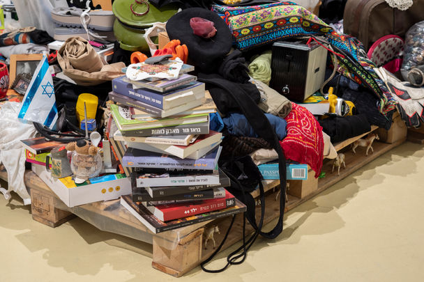 Pile of books and various objects on a wooden pallet. Installation view. MIC - Made In China by Dafna Talmon