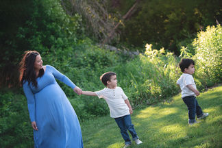 Mother in a flowing blue dress holding the hand of her son
