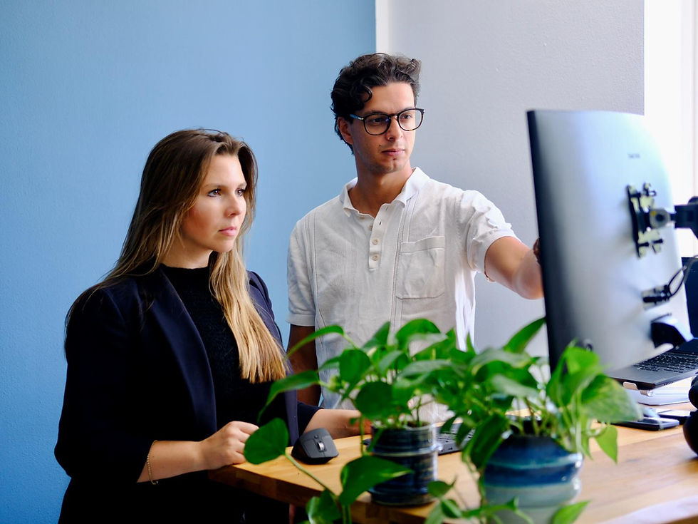 Webdesigner Adam und SEO-Expertin Marilena aus Graz besprechen am Bildschirm die Entwicklung einer neuen Website.