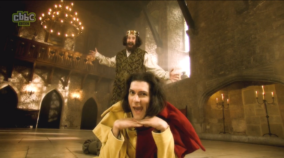 King Henry and a jester pose in a royal courtroom to end the song