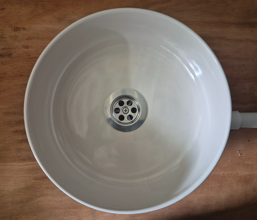 Top view of sage green ceramic campervan sink showing cream interior and waste