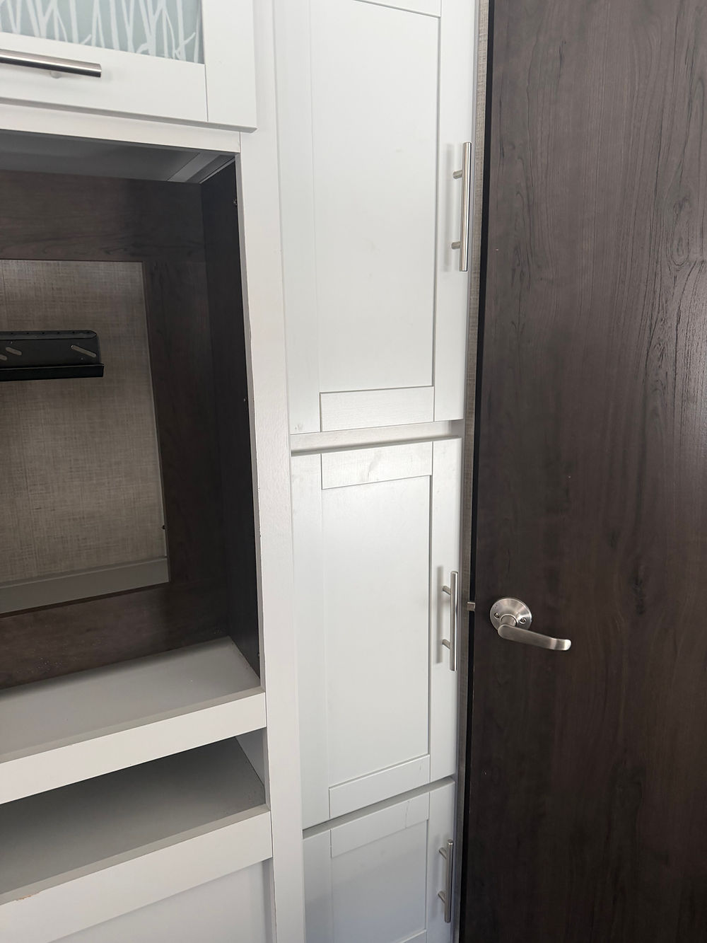 White cabinets and dark wood door in Keystone Bullet 290BHS