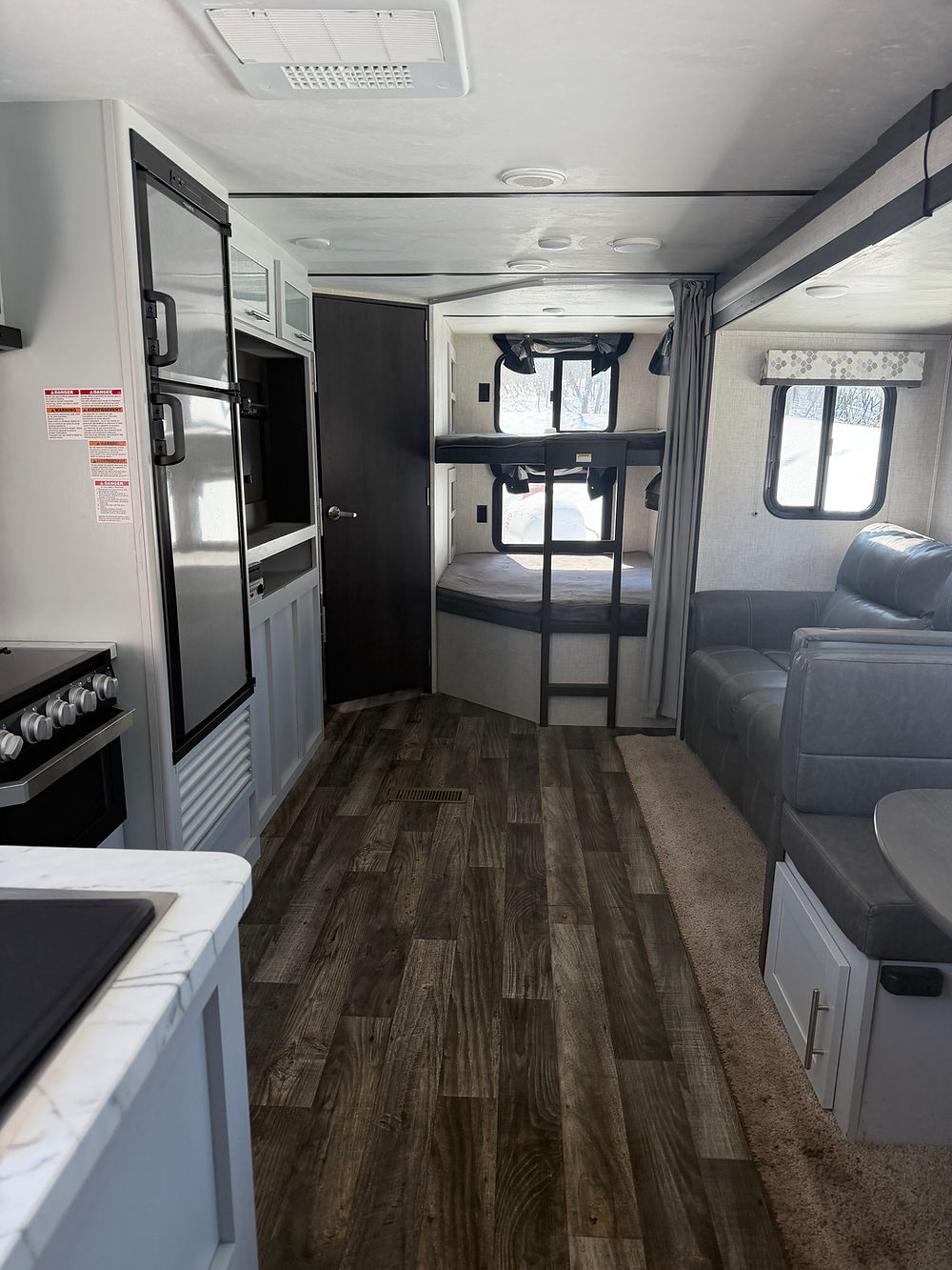 Interior of a Keystone Bullet 290BHS with kitchen, bunk beds, and dinette