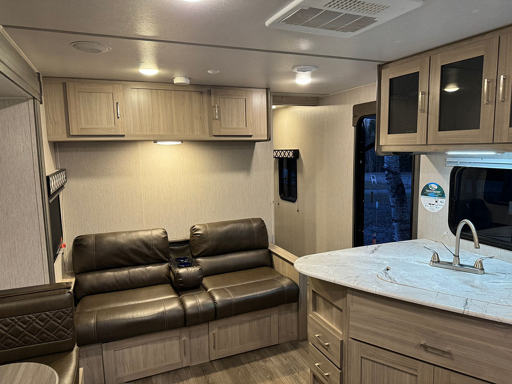 2020 Coachman Freedom Express interior with sofa and kitchen.