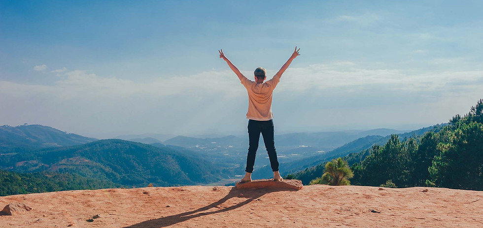 A person celebrating on top of a mountain