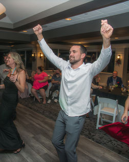 Man dancing with arms raised, joyous celebration at the event PHOTOGRAPHY