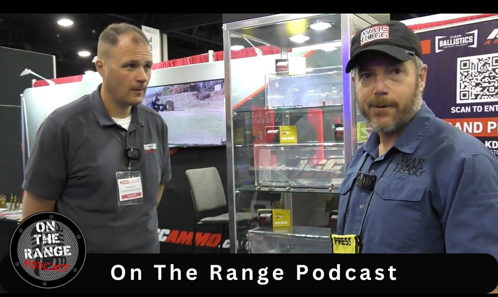 Rick Hogg founder War HOGG Tactical and Mike Hoskavich at the ICC Ammo booth with glass displays. One wears a blue shirt and cap, the other a gray polo. "On The Range Podcast" text below.