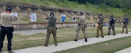 Several men firing pistols at targets during law enforcement firearms training.