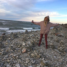 Woman standing on the rocky Saaremaa coast during a private nature retreat for rest and inner peace.