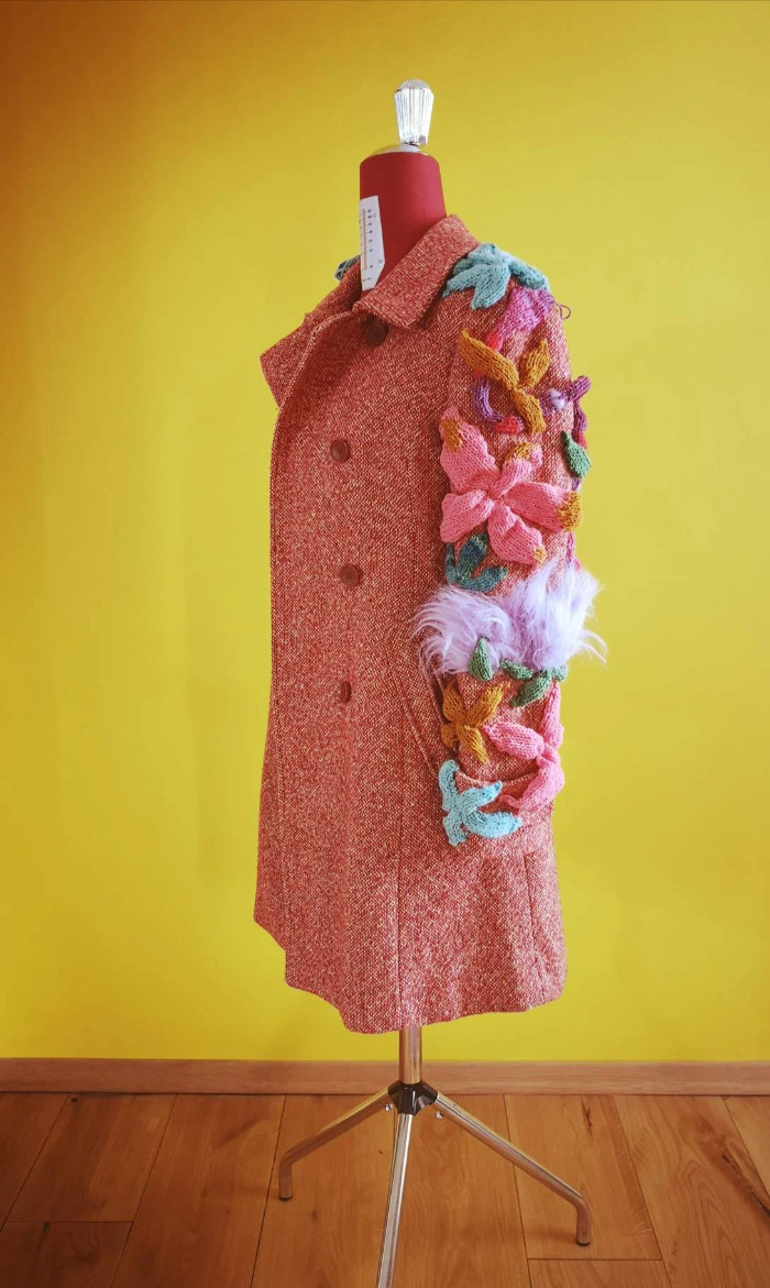 Thumbnail: Detailed close-up of hand-knitted three-dimensional botanical sculptures made from vintage wool on a DURGA upcycled coat