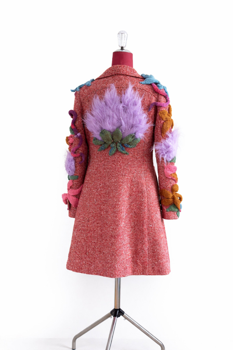 Thumbnail: Back view of DURGA art coat featuring a three-dimensional light purple faux-fur lotus sculpture with hand-knitted leaves