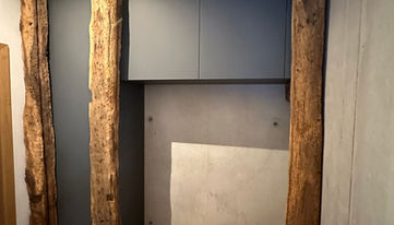 Garderobe mit anthrazitfarbenen Fenix-Fronten und einzigartigen Balkenelementen aus einem Abbruchhaus – individuell gefertigt von der Schreinerei Andrejewski