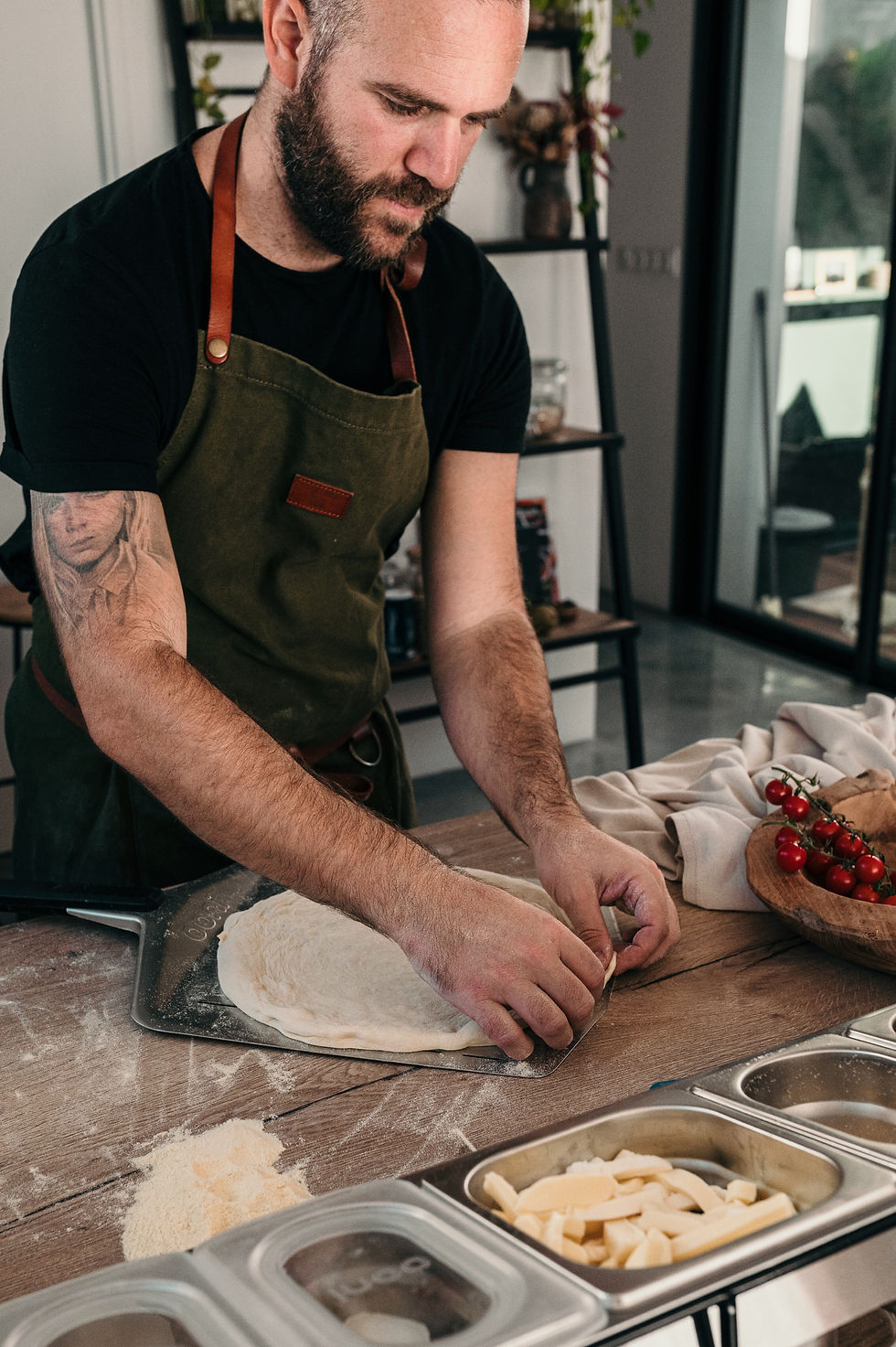 Notre chef pizzaiollo étalant la pâte à pizza