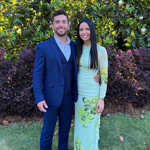 Kaleb Lagos Perspective Designs and Renovation Owner and Wife standing in front of beautiful bushes