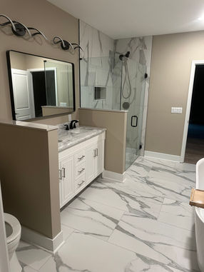 Modern bathroom renovation in Buford GA with walk-in shower, black fixtures, and floating vanity by Perspective Design and Renovations.