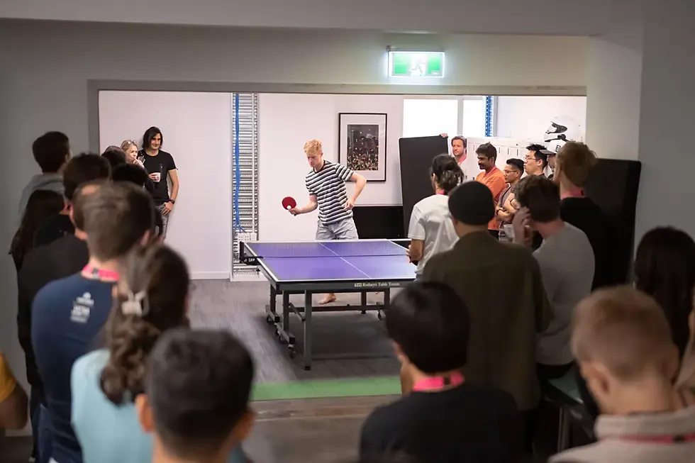 Group of people watching a table tennis match in the office