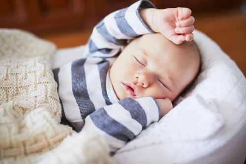 Baby taking a nap with one hand stretched over head