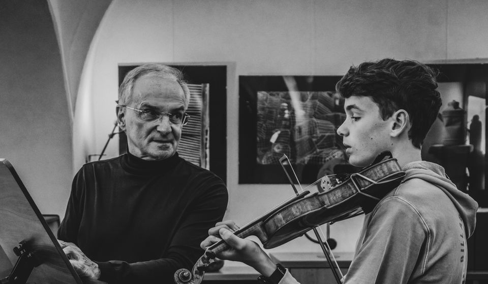 Eine schwarz-weiß-Aufnahme von Leonhard Grünwald und seinem Schüler beim Violin-Unterricht im Amberger Kulturstadel.