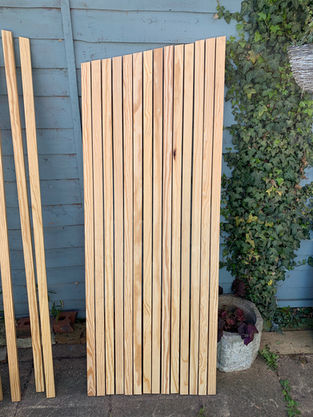 Wood strips leaning up against blue fence