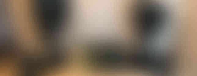 Studio desk with rack units built in on steel legs in a room with speakers on stands