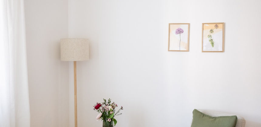 Zwei Stühle stehen sich im Licht einer Stehlampe gegenüber.