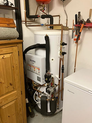 A home water heater setup with pipes and a freezer
