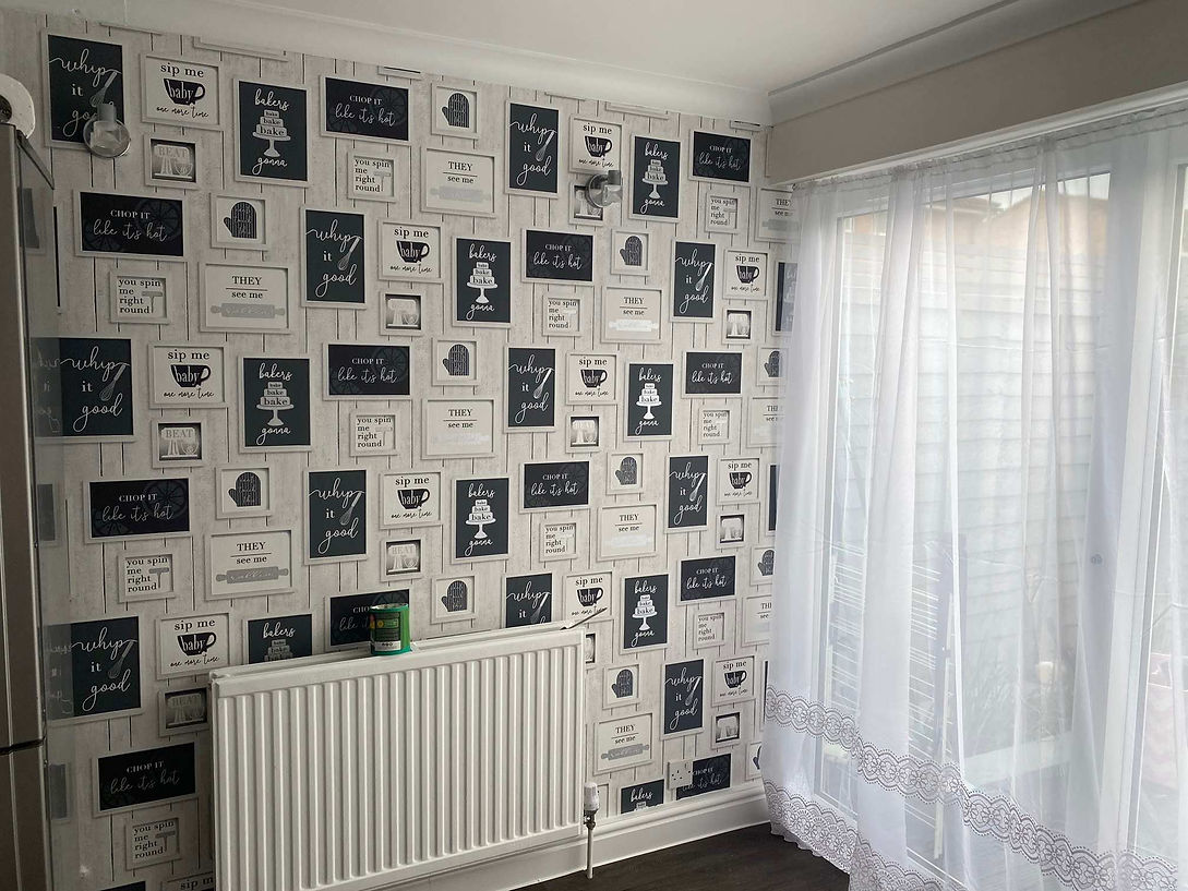 A room with a wall covered in framed kitchen-themed quotations