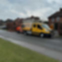 A yellow truck from E. Smith Tree Services is parked on a road