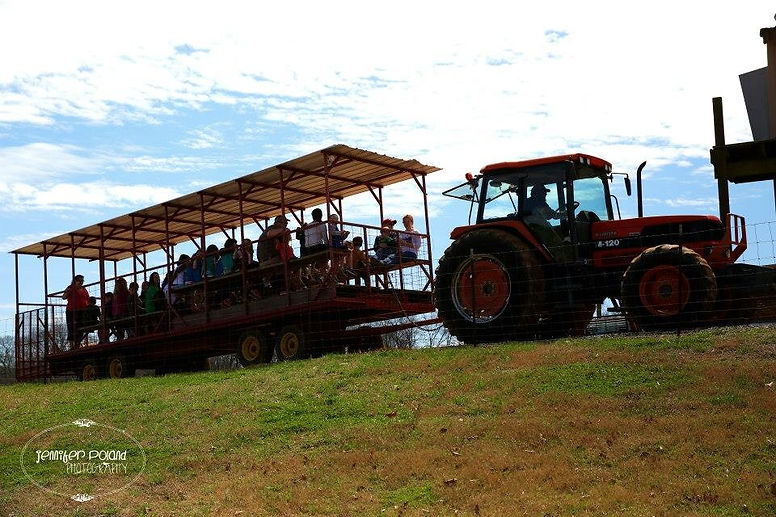 Tractor pulling a group of people on a hey ride.