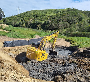 Excavator operating in soft ground during detailed earthworks