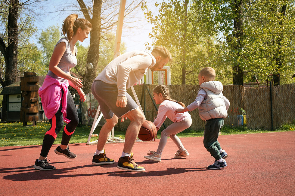 Caucasian family playing basketball toge