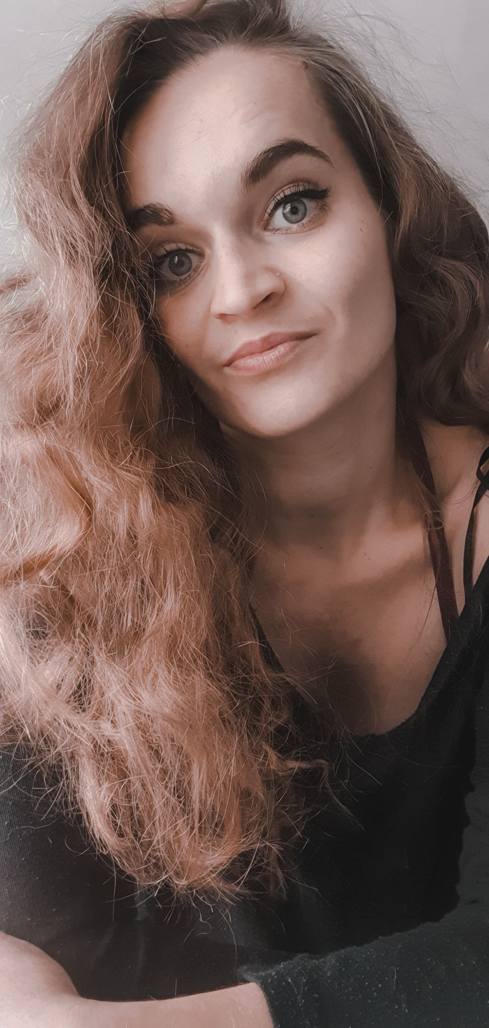 Tena leaning towards the camera, wearing a black top and thinking about the "Made in Europe" and ethics