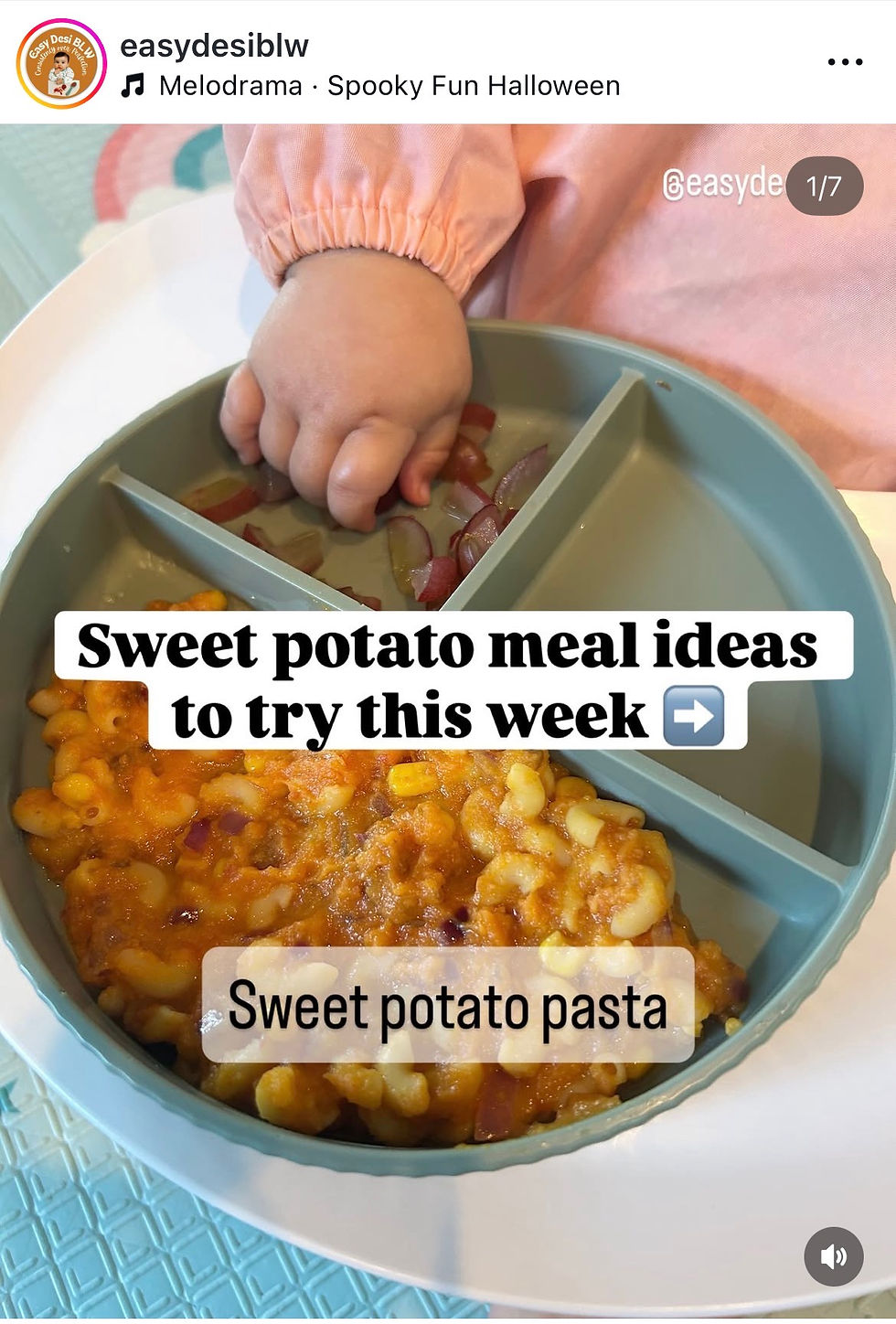 Baby hand reaching for food in a divided plate with sweet potato pasta and quartered grapes. Text reads "Sweet potato meal ideas to try this week."