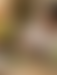 A Black woman herbalist in a white shirt working at a rustic wooden table, grinding herbs with a stone mortar and pestle in a warm, apothecary-style kitchen filled with jars and dried plants. Soultribe Media sign logo