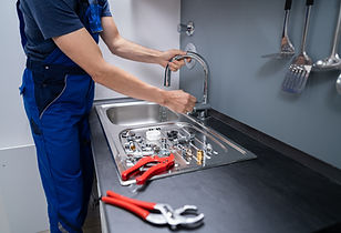 Plumber fixing a kitchen faucet
