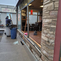 A man is engaged in work on a building, which features an open door