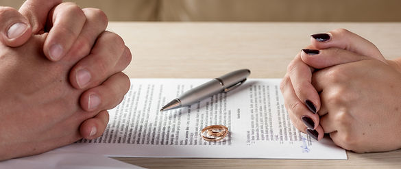 Wife and husband signing divorce documents or premarital agreement