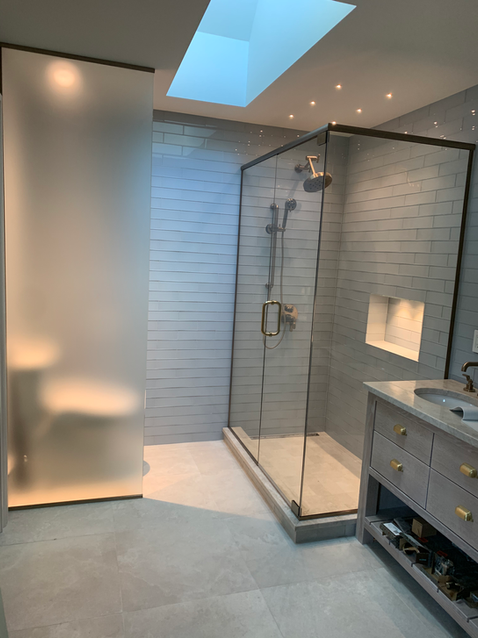 Salle de bain élégante avec douche en verre et toilettes.