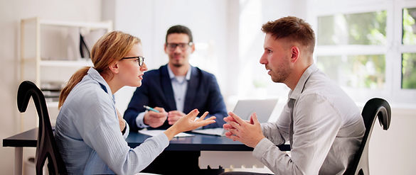 Professional lawyers mediating a tense argument between a young Hispanic couple