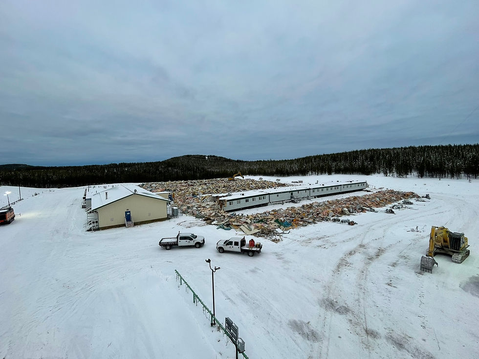 Snow covered oilfield construction site with service vehicles