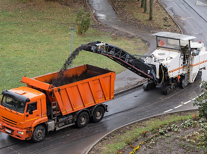 Road milling machine removes old asphalt and loads milled asphalt