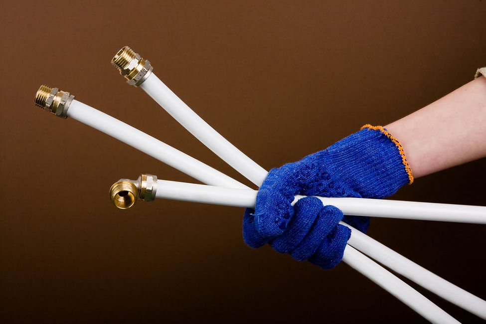 A person grasping three white pipes, showcasing a focus on construction or plumbing materials in a hands-on context