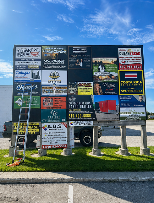 Outdoor display structure showing multiple local business advertisement boards