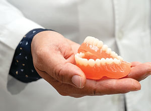 dentist holding dental teeth model