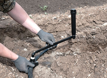 Plumber installs a sprinkler for automatic watering using a flexible connection