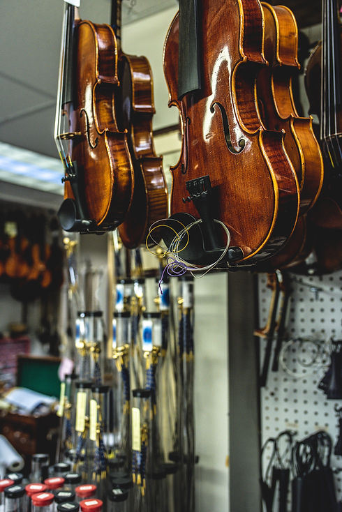 violins are handing in a shop ready for finishing