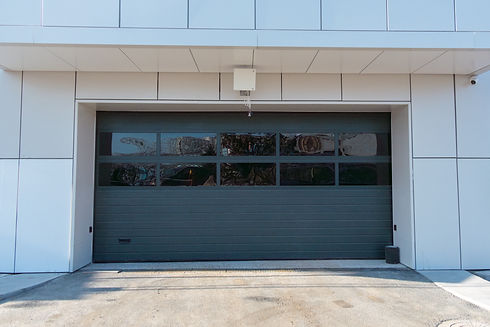 Modern commercial garage door with large glass panels and sleek design