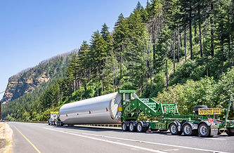 Heavy duty big rig semi truck transporting part of long oversized windmill generator pole