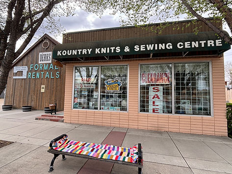 Kountry Knits & Sewing Centre storefront with a colorful knitted blanket on a bench