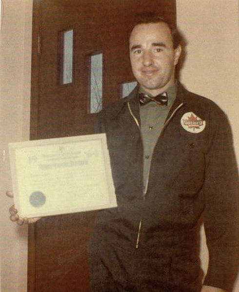 Uniformed towing employee holding certificate inside office building